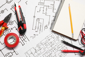 Tools and office stationery on wiring diagrams, top view