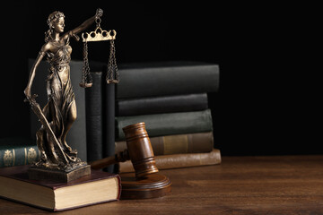 Obraz na płótnie Canvas Symbol of fair treatment under law. Statue of Lady Justice near books and gavel on wooden table, space for text.