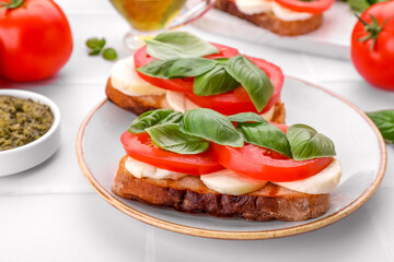 Delicious Caprese sandwiches with mozzarella, tomatoes and basil on white table, closeup