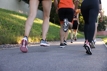 Fototapeta premium Group of people running outdoors, closeup view