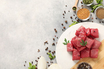 Raw beef meat and different ingredients for cooking delicious goulash on light grey table, flat lay. Space for text