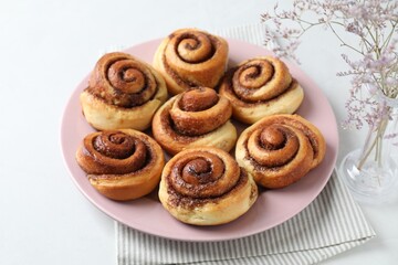 Many tasty cinnamon rolls on white table, closeup