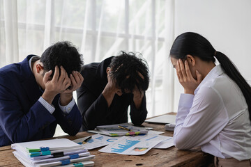 A group of stressed-out young Asian businessmen searching for a solution to a problem at a partnership meeting are left scratching their heads over bad news of a failed attempt. Feeling hopeless about - obrazy, fototapety, plakaty