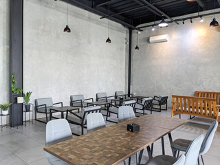 Modern tables and chairs are neatly arranged in a cafe
