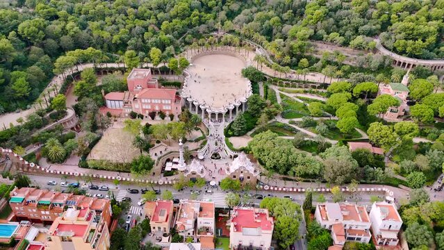Aerial drone view of Park Guell. Antoni Gaudi architecture. A lot of greenery around, tourists, Barcelona, Spain