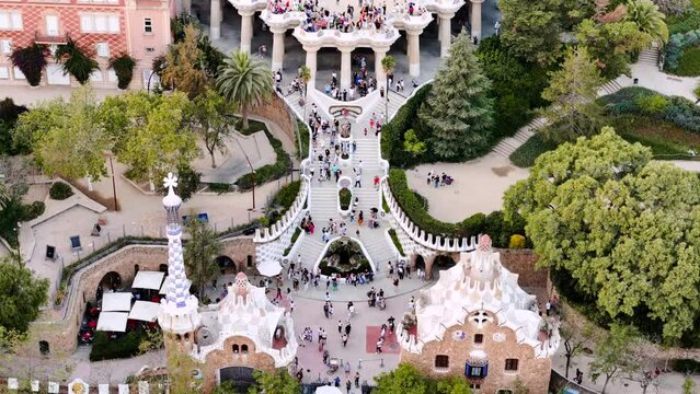 Aerial drone view of Park Guell. Antoni Gaudi architecture. A lot of greenery around, tourists, Barcelona, Spain