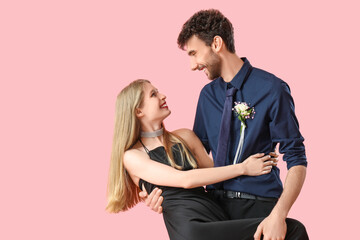 Beautiful prom couple dancing on pink background