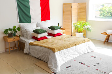 Interior of stylish bedroom with hanging Italian flag