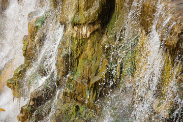 Beautiful waterfall between large rocks in the autumn forest. Sofievskiy park in Uman, Ukraine