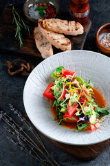 Italian salad with fresh vegetables. Vegetarian Mixed salad of tomatoes, cucumbers, avocado and greens on bowl
