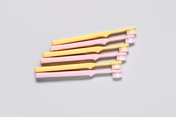 Colorful plastic toothbrushes on grey background.