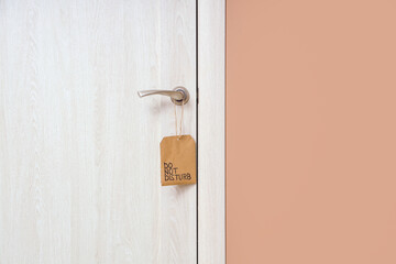 Wooden door with hanger in hotel room, closeup