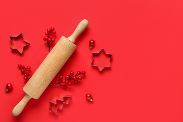 Beautiful composition with rolling pin and molds on red background on beige background