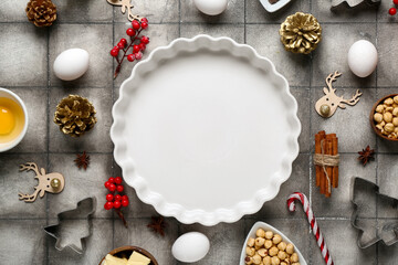 Composition with different ingredients for preparing Christmas pie on grey tile background