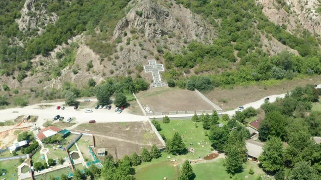 Pedestal-up drone shot of a cross sculpture built for the consecration of St. Petka in Rupite, Bulgaria in honor of the volcano eruption victims as ordered by Bulgarian prophetess Baba Vanga.
