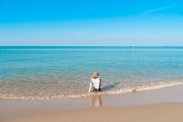 Fototapeta na wymiar Tropical sea beach with young girl relaxing on sand