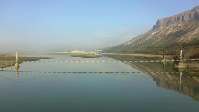 Aerial backwards shot of bridge at Studen Kaldenets Reservoir during sunny day