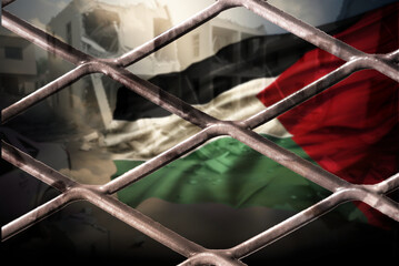 Flagge von Palästina und Trümmer hinter einem Zaun