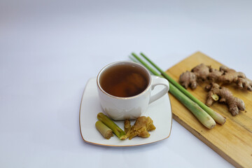 Herbal green tea with lemongrass and ginger in glass cup with fresh limes