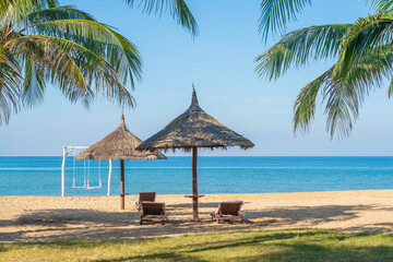 Tropical beach with palm tree and leaf umbrellas