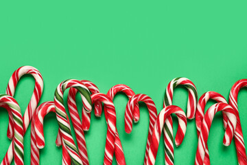 Many Christmas candy canes on green background