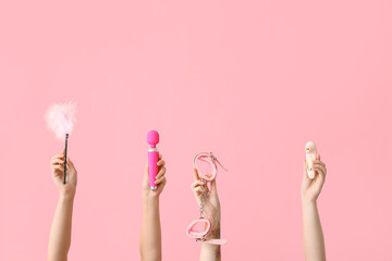 Women holding sex toys on pink background - obrazy, fototapety, plakaty