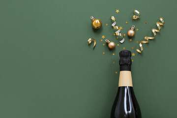 Champagne bottle with Christmas decor on green background