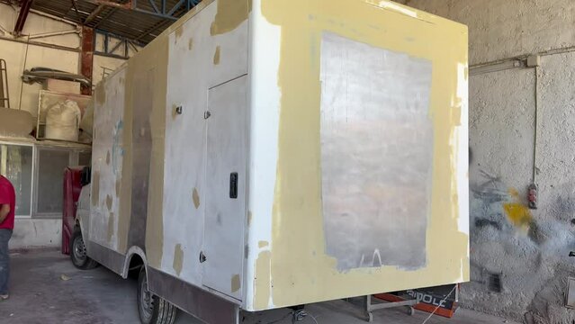 A caravan that has been puttyed, surface defects removed and prepared for painting in the industry