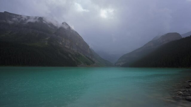 Turquoise surface of Lake Louise on a rainy day in summer. Timelapse. 