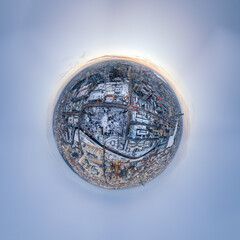 Aerial winter city view with crossroads and roads, houses, buildings, parks and bridges. Copter shot. Little planet sphere mode.