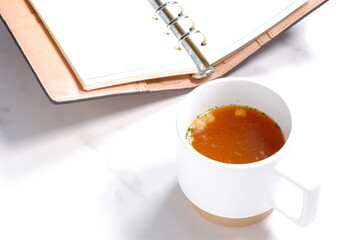 熱々のオニオンコンソメスープと手帳
