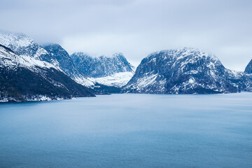 Norwegian fjord landscape in winter. Mountains and sea.