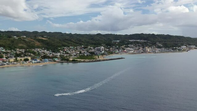 High drone footage of speedboat sailing near to Rompeolas Beach in Aguadilla, Puerto Rico