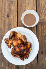 Delicious Lechon Manok, or roasted chicken served outside at a bench with gravy.
