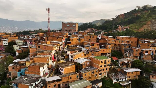 Flying over old favela homes of Comuna 13, sunny Medellín, Colombia - Aerial view