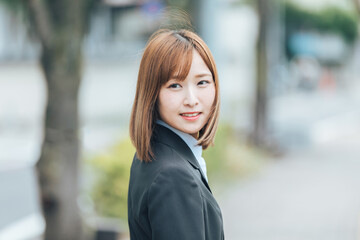 振り返って微笑むスーツの女性　Business	