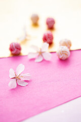 日本の正月イメージ　桜の花と水引玉と和紙のデザイン（ピンクと金色の和紙の背景）