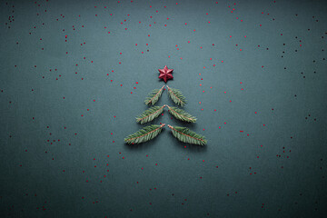 Small Christmas tree on green textured paper. Christmas texture background copy space