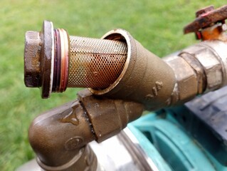 The dirty water filter is unscrewed and pushed out for subsequent replacement. Maintenance and repair of the water supply system of the house.