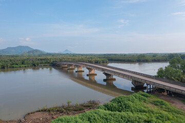 Fototapeta na wymiar Aerial top view of a bridge with garden park with green mangrove forest trees, river, pond or lake. Nature landscape background, Thailand.