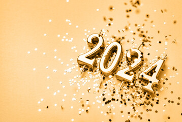 New Year 2024 celebration festive background with copy space made with golden candles in the form...