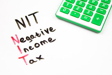 NIT Negative Income Tax inscription with marker on blackboard. NIT acronym, taxation concept.