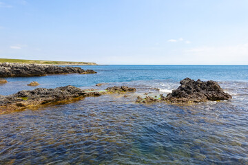 Cape Tarkhankut on the Crimean peninsula. The rocky coast of the Dzhangul Reserve in the Crimea. A sunny summer day. The Black Sea. Turquoise sea water.