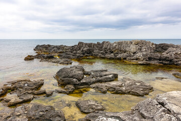 Fototapeta na wymiar Cape Tarkhankut on the Crimean peninsula. The rocky coast of the Dzhangul Reserve in the Crimea. A sunny summer day. The Black Sea. Turquoise sea water.
