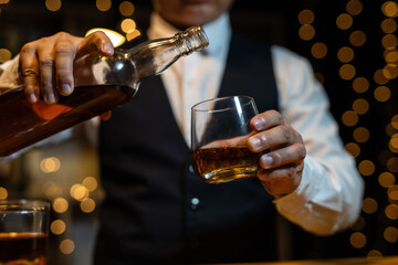 Barman pouring whiskey whiskey glass..