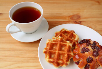Belgian Waffles with a Cup of Hot Tea on Wooden Table
