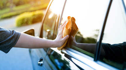 Naklejka premium Woman hand cleaning car with a cloth