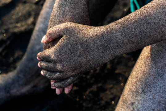Hands covered with black sand