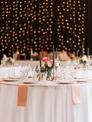 Elegant event tablescape with floral centerpiece and bokeh strin