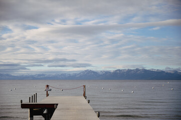 View of dock into lake tahoe with mountains in the background